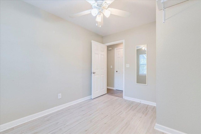 spare room featuring baseboards, ceiling fan, and light wood-style flooring