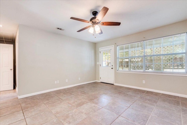 empty room with visible vents, a ceiling fan, baseboards, and attic access