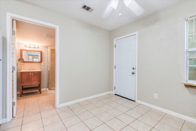 unfurnished room featuring baseboards, ceiling fan, visible vents, and light tile patterned floors