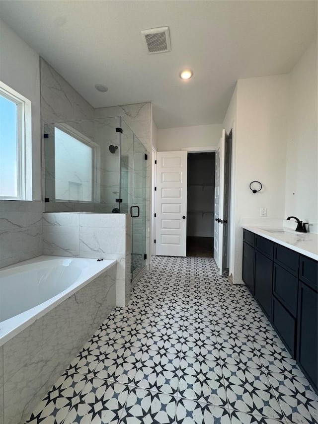 1410 Cardinal Ln, Round Rock, TX 78681 - bathroom with a bath, a marble finish shower, tile patterned floors, vanity, and recessed lighting