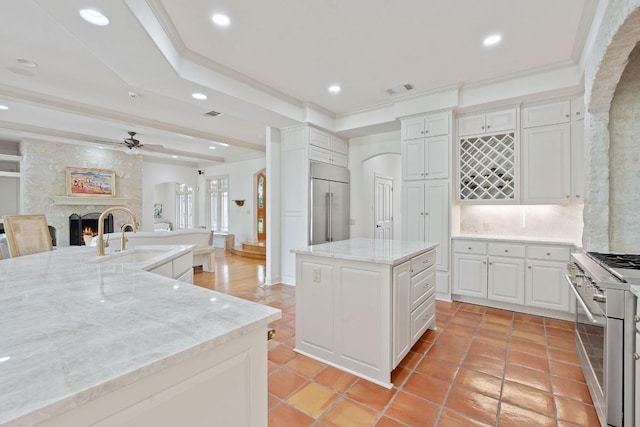 kitchen featuring ceiling fan, a sink, a center island, open floor plan, and high end appliances