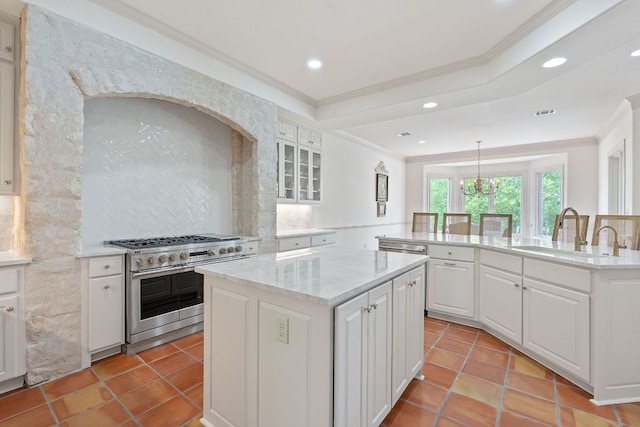 kitchen with a sink, crown molding, a kitchen island, and range with two ovens