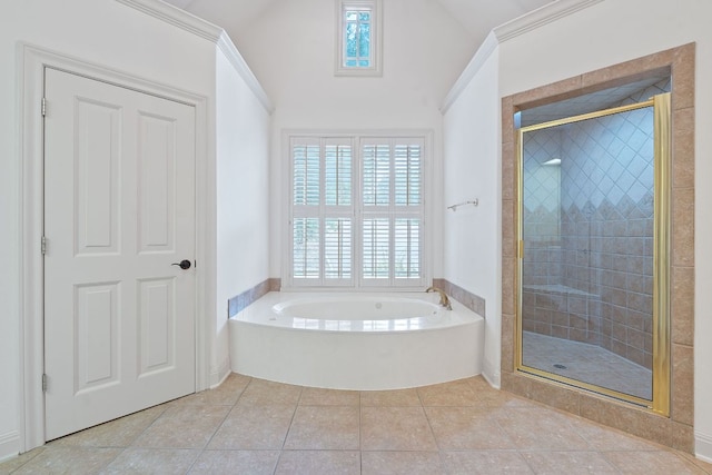 bathroom with tile patterned floors, a shower stall, a garden tub, and lofted ceiling