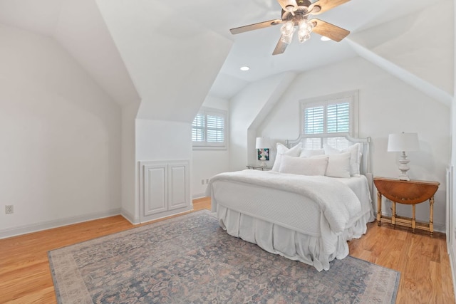 bedroom with baseboards, vaulted ceiling, and light wood-style flooring