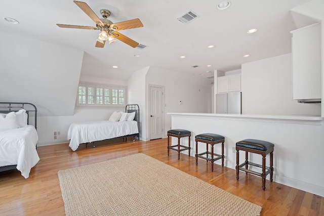 bedroom with visible vents, recessed lighting, light wood-style flooring, and stainless steel refrigerator