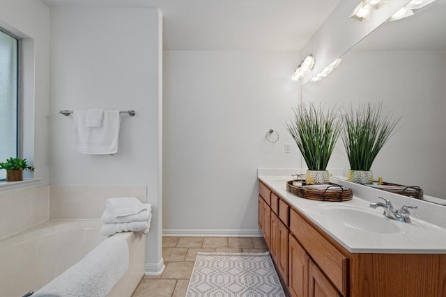 full bathroom with double vanity, tile patterned floors, a healthy amount of sunlight, and a sink