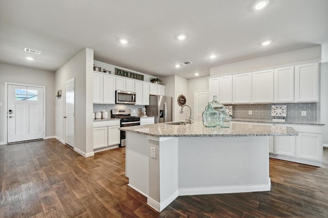 kitchen featuring backsplash, stainless steel appliances, visible vents, and dark wood finished floors