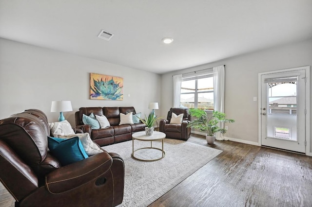 living area featuring baseboards, dark wood-style flooring, and visible vents