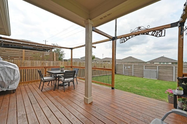 wooden deck with a fenced backyard, outdoor dining area, a lawn, and grilling area