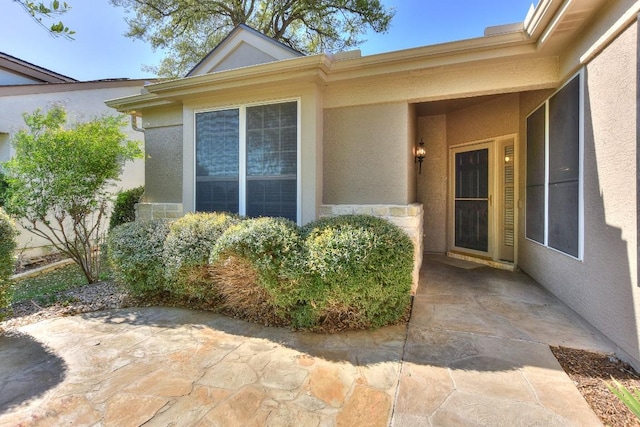 doorway to property featuring a patio area and stucco siding
