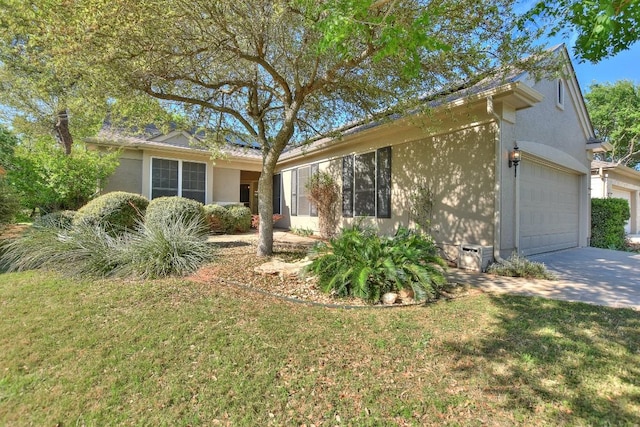 ranch-style home featuring concrete driveway, an attached garage, a front yard, and stucco siding