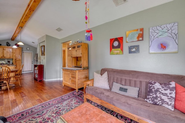 living room with visible vents, wood finished floors, and vaulted ceiling with beams