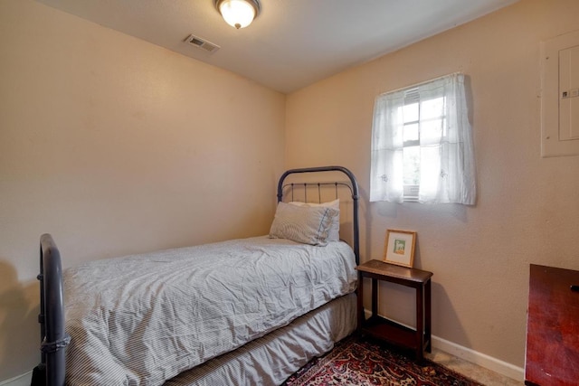bedroom with baseboards, electric panel, and visible vents