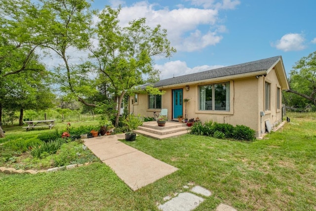 view of front of property featuring a front lawn and stucco siding