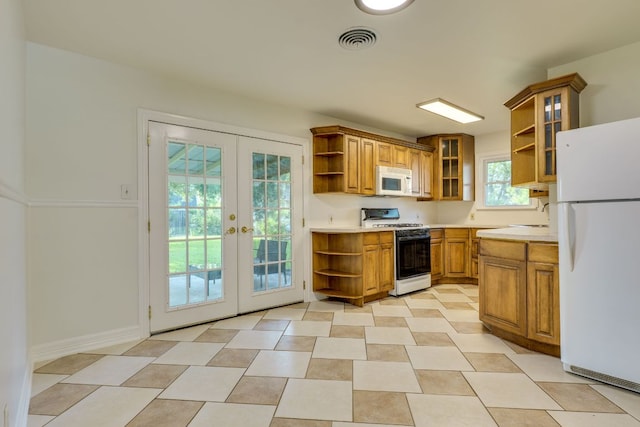 8504 Burrell Dr, Austin, TX 78757 - kitchen featuring open shelves, white appliances, french doors, and brown cabinets