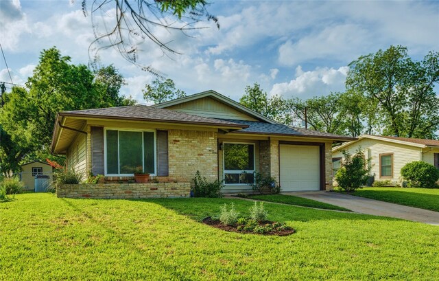 ranch-style home featuring a front lawn, fence, brick siding, an attached garage, and driveway
