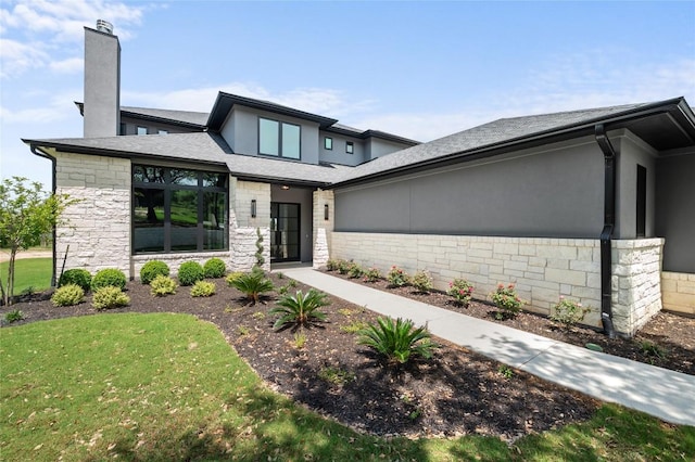 3202 Winding Creek Cv, Austin, TX 78735 - contemporary house featuring stone siding, a chimney, a front yard, roof with shingles, and stucco siding