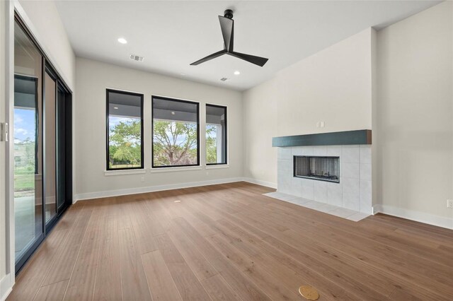 unfurnished living room featuring a ceiling fan, baseboards, visible vents, and wood finished floors