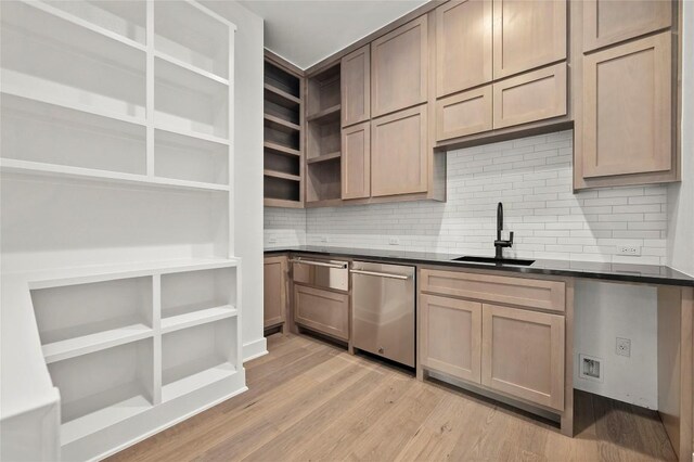 kitchen featuring dark countertops, open shelves, dishwasher, a sink, and light wood-style flooring