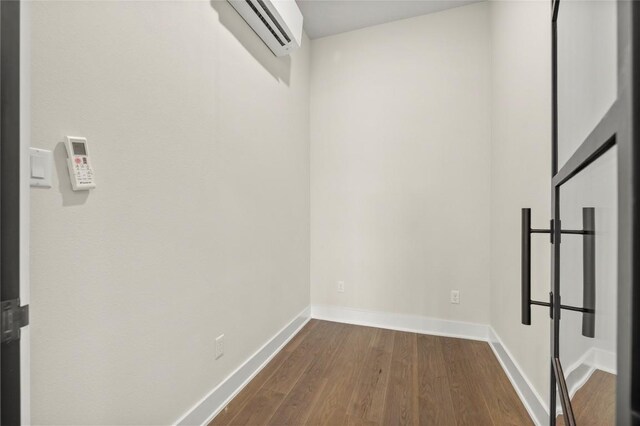 walk in closet with an AC wall unit and dark wood finished floors