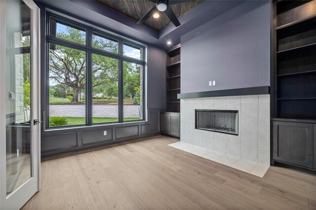 3202 Winding Creek Cv, Austin, TX 78735 - unfurnished living room with built in features, light wood-style floors, a ceiling fan, and a fireplace