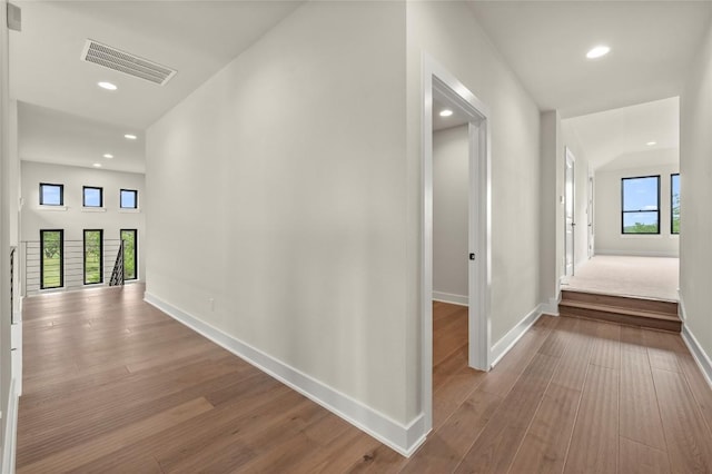 hall with baseboards, recessed lighting, wood finished floors, and visible vents