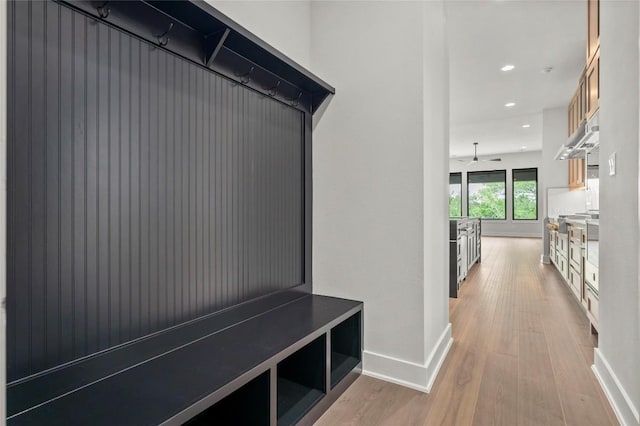 mudroom with recessed lighting, baseboards, and light wood finished floors