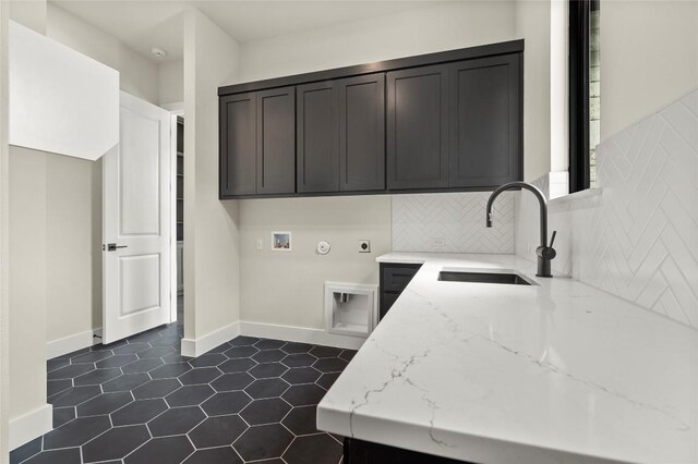 laundry room featuring cabinet space, washer hookup, a sink, electric dryer hookup, and dark tile patterned flooring