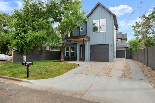 6110 Atwood St Unit 1, Austin, TX 78741 - view of front facade featuring board and batten siding, driveway, a front yard, fence, and an attached garage