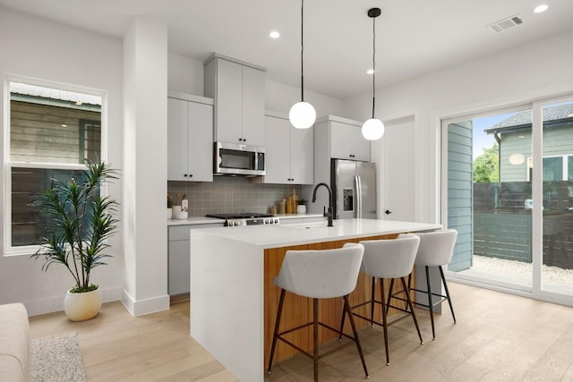 6110 Atwood St Unit 1, Austin, TX 78741 - kitchen featuring a sink, stainless steel appliances, light wood-type flooring, backsplash, and visible vents