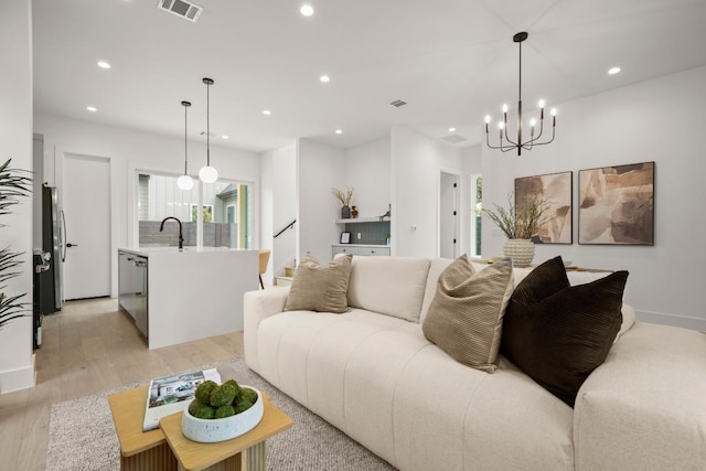 6110 Atwood St Unit 1, Austin, TX 78741 - living room featuring recessed lighting, a chandelier, light wood-style flooring, and visible vents