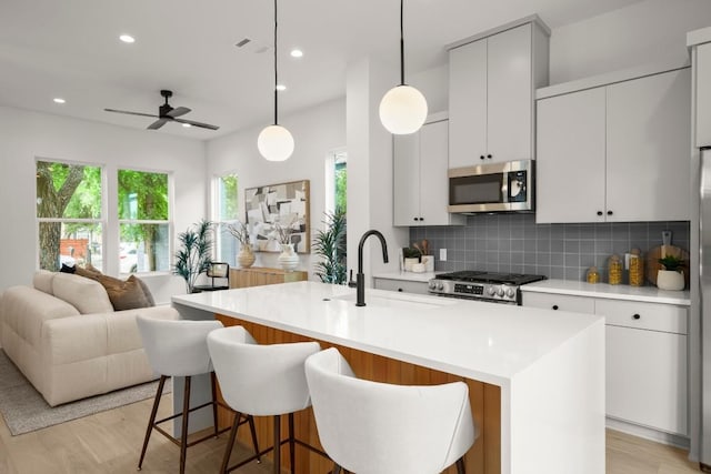6110 Atwood St Unit 1, Austin, TX 78741 - kitchen featuring ceiling fan, stove, a sink, stainless steel microwave, and open floor plan