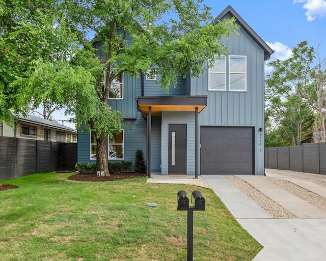 6110 Atwood St Unit 1, Austin, TX 78741 - view of front of house with board and batten siding, fence, concrete driveway, and a garage