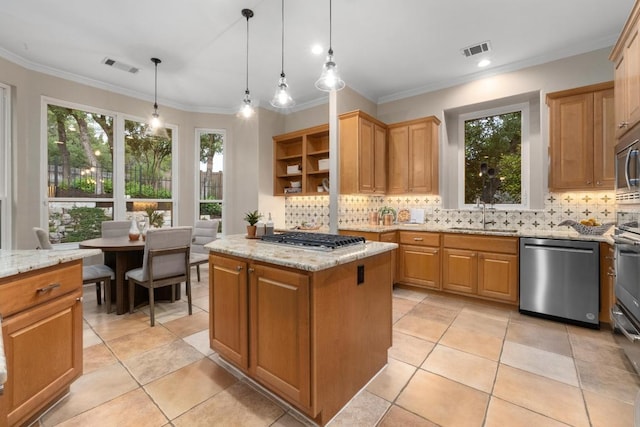 kitchen with appliances with stainless steel finishes, decorative backsplash, a sink, and visible vents