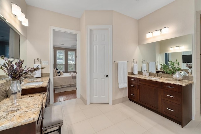 ensuite bathroom with vanity, baseboards, tile patterned floors, and ensuite bath