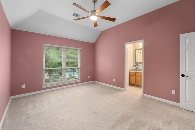 unfurnished bedroom featuring baseboards, light carpet, lofted ceiling, and visible vents