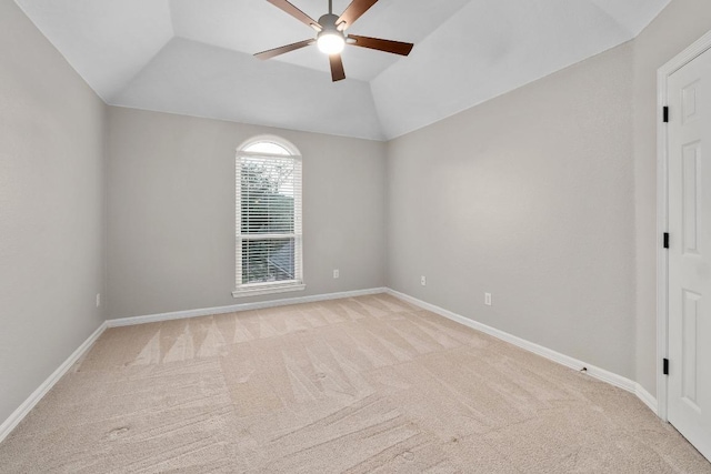 unfurnished room with baseboards, a ceiling fan, vaulted ceiling, and light carpet