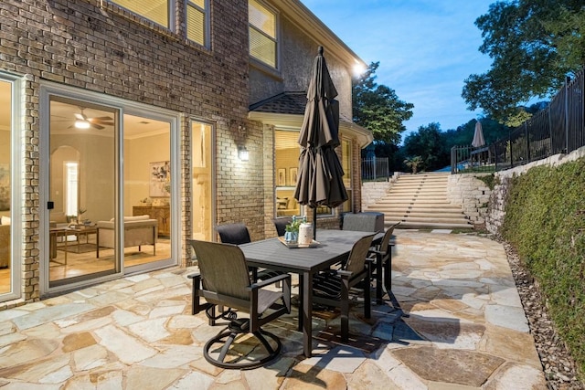 view of patio / terrace featuring stairs, fence, and outdoor dining space