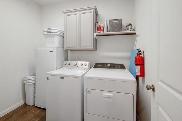 2229 Sauterne Dr, Leander, TX 78641 - laundry area featuring dark wood-style flooring, independent washer and dryer, cabinet space, baseboards, and water heater