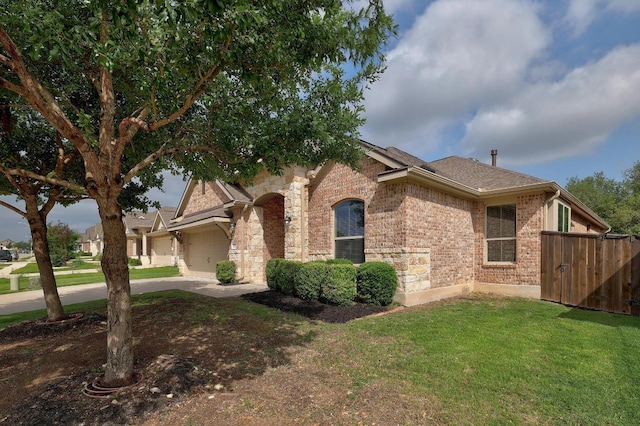 2229 Sauterne Dr, Leander, TX 78641 - view of home's exterior with fence, an attached garage, brick siding, concrete driveway, and a yard