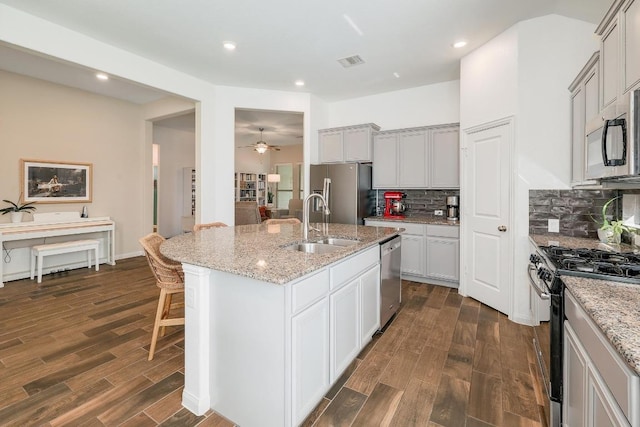 2229 Sauterne Dr, Leander, TX 78641 - kitchen with a sink, decorative backsplash, dark wood-style floors, and stainless steel appliances
