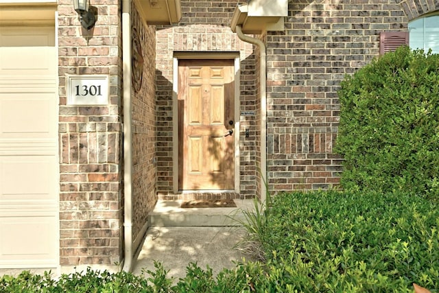 property entrance featuring brick siding