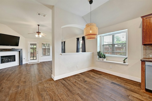 interior space featuring dark wood-style flooring, visible vents, a wealth of natural light, and vaulted ceiling