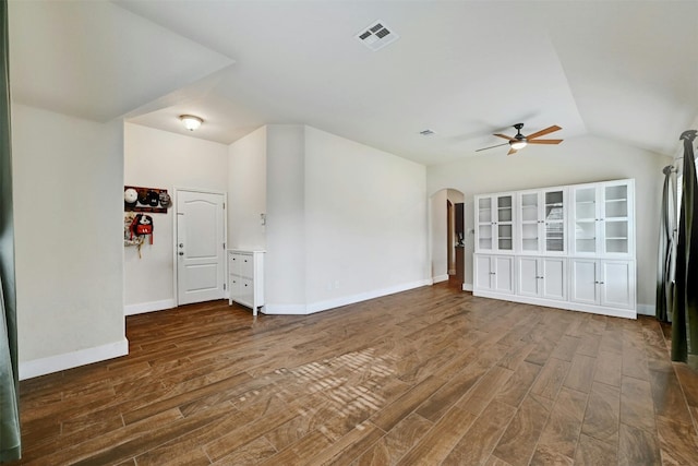 interior space featuring arched walkways, ceiling fan, wood finished floors, and visible vents