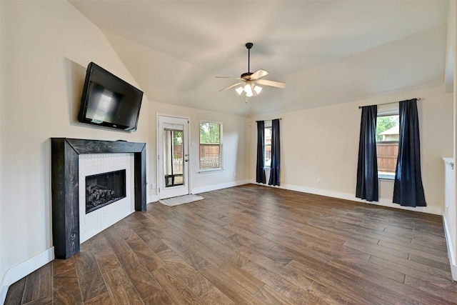 unfurnished living room featuring plenty of natural light, baseboards, a glass covered fireplace, and ceiling fan