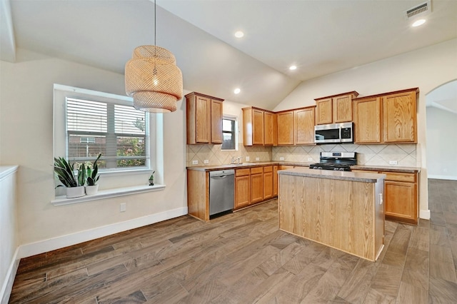 kitchen with visible vents, tasteful backsplash, vaulted ceiling, and stainless steel appliances