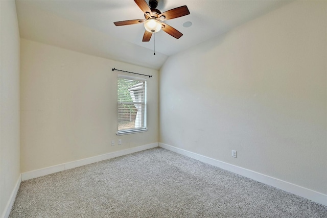 spare room featuring baseboards, light carpet, and vaulted ceiling