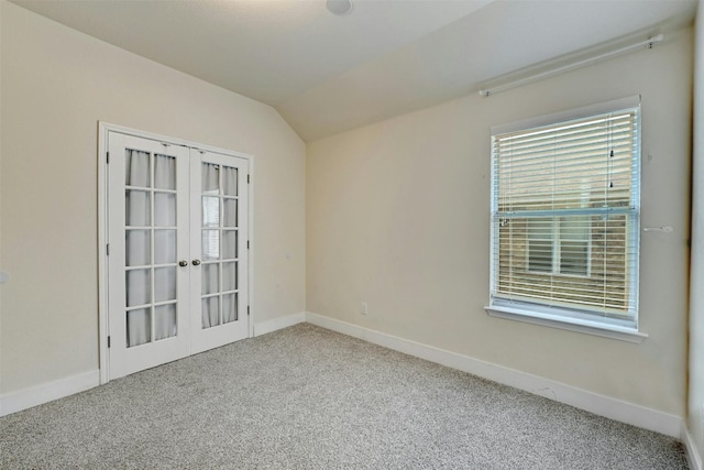 carpeted empty room with french doors, baseboards, and lofted ceiling