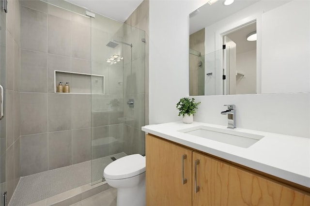 full bathroom featuring vanity, tile patterned floors, a stall shower, and toilet