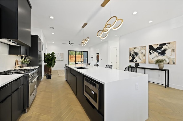 kitchen featuring a sink, appliances with stainless steel finishes, dark cabinetry, and light countertops